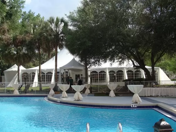Experience the Party Plus Difference. The table on the front left showcases linens that have undergone our specialized commercial cleaning and pressing process. In contrast, the table on the back right features linens that were packaged in squares and not pressed, highlighting the clear distinction in quality.